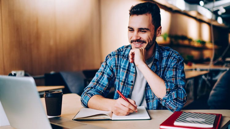 A college student applies for scholarships while sitting at his desk.