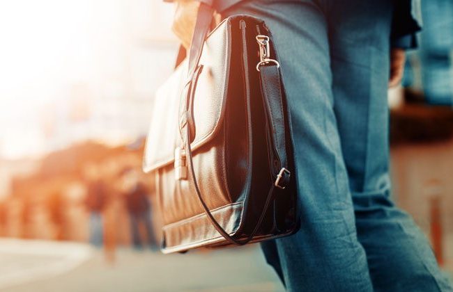 Man holding briefcase prepares for his first day at a new job.