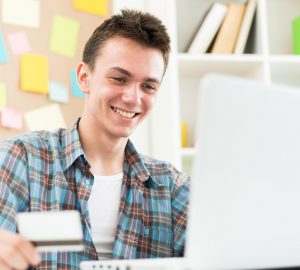 College student holding credit card and shopping on internet