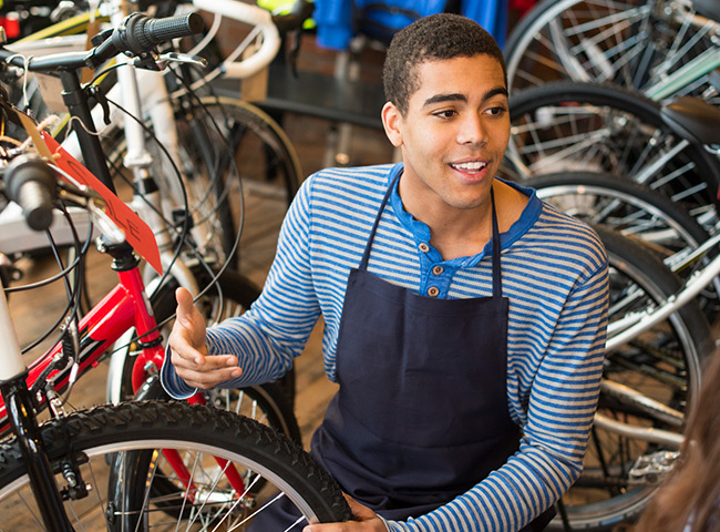 A young man works in a bike shop.