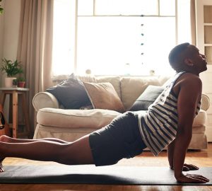 A college student performs a yoga pose at home.