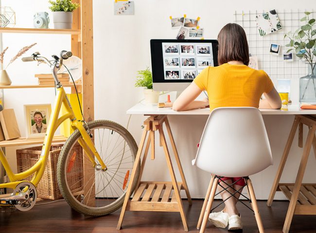 A student sits at a desk while working a summer job from home.