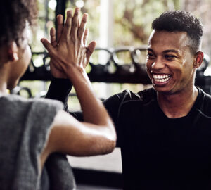Young people high five each other at the gym